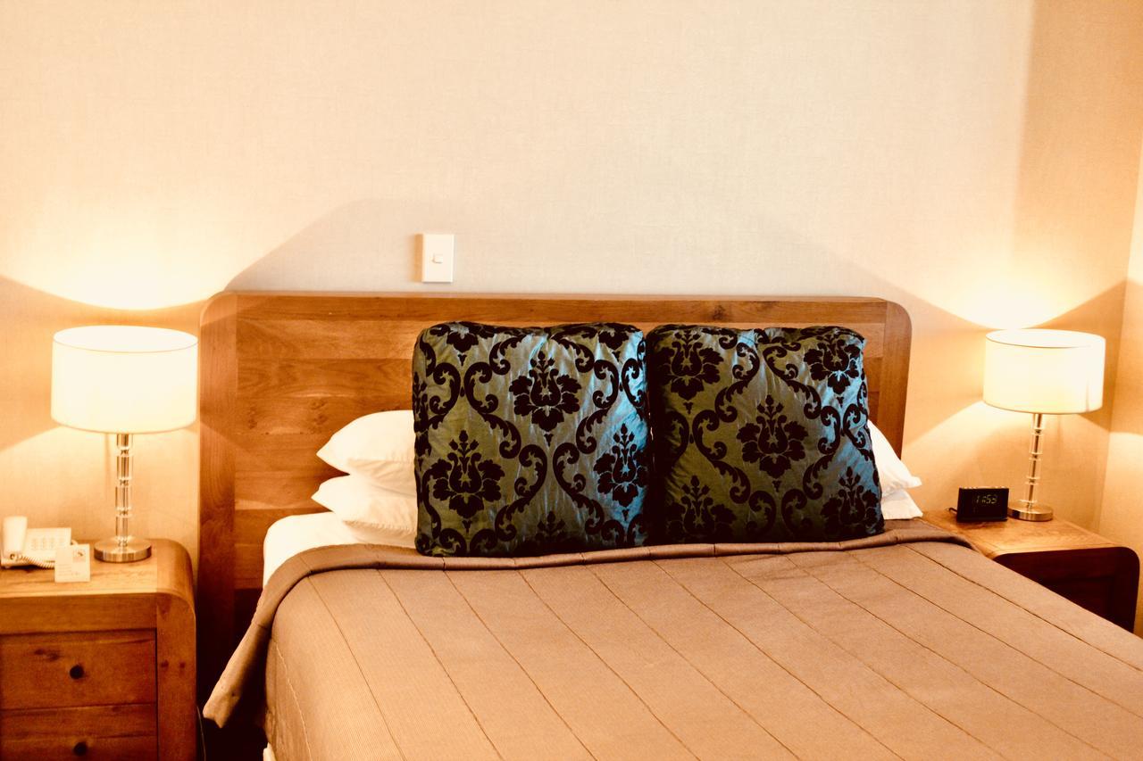 The Nautilus Hotel Нейпиър Екстериор снимка A bed with a decorative pillow