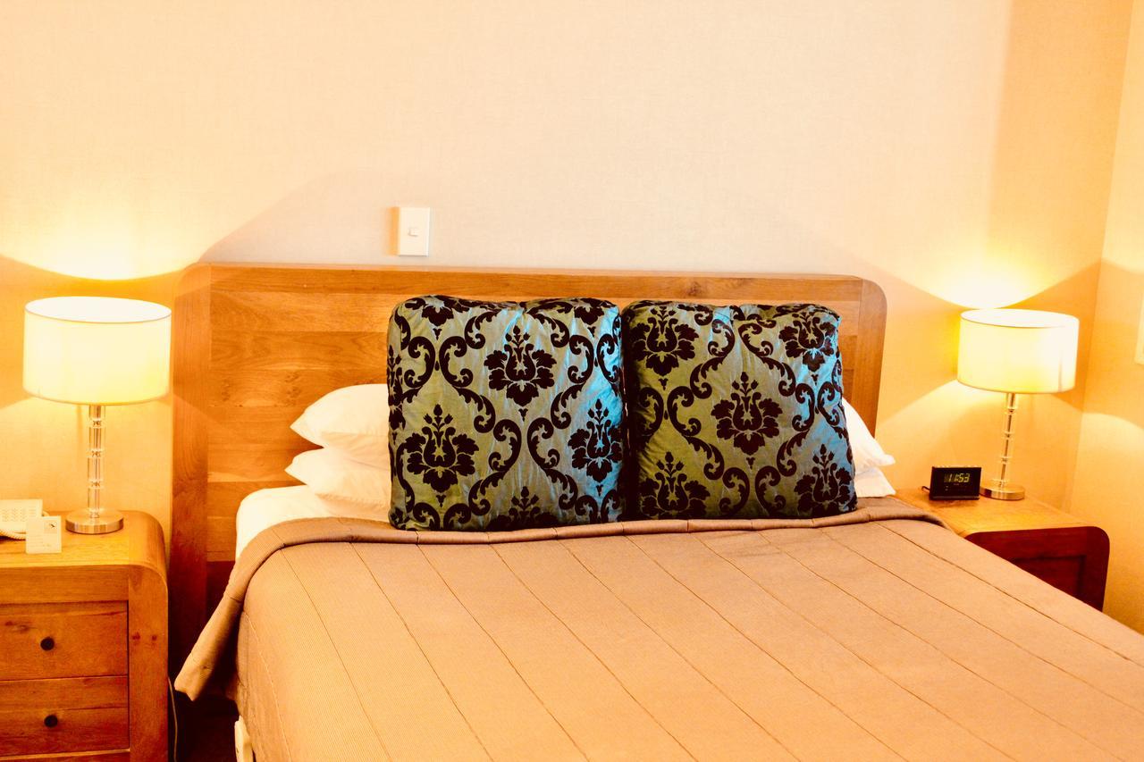 The Nautilus Hotel Нейпиър Екстериор снимка A bed with a decorative pillow